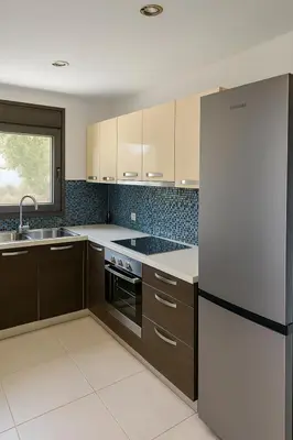 a kitchen with brown cabinets and a black refrigerator at Villa Solmar Rhodes in Lachania