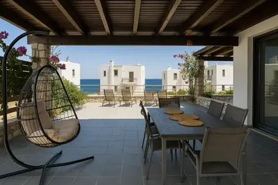 a patio with a hammock and a table and chairs at Villa Solmar Rhodes in Lachania