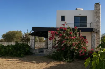 a house with a flower bush in front of it at Villa Solmar Rhodes in Lachania