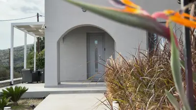 a white building with a door and some plants at ARYVE Townhouse Rhodos mit Akropolis- und Meerblick sowie Jacuzzi und tollen Sonnenterrassen und Garten in Malona Village