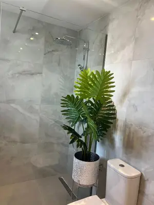 a bathroom with a toilet and a plant in it at ARYVE Townhouse Rhodos mit Akropolis- und Meerblick sowie Jacuzzi und tollen Sonnenterrassen und Garten in Malona Village
