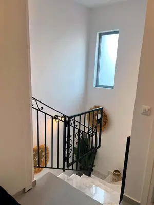 a stairway with a black railing and a window at ARYVE Townhouse Rhodos mit Akropolis- und Meerblick sowie Jacuzzi und tollen Sonnenterrassen und Garten in Malona Village