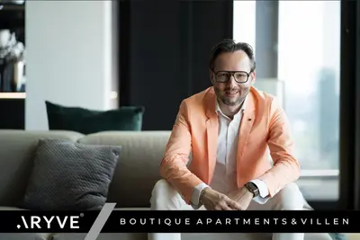 a man in an orange suit sitting on a couch at ARYVE Townhouse Rhodos mit Akropolis- und Meerblick sowie Jacuzzi und tollen Sonnenterrassen und Garten in Malona Village