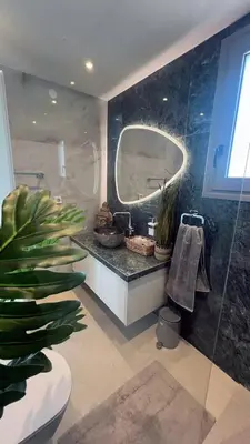 a bathroom with a sink and a mirror and a plant at ARYVE Townhouse Rhodos mit Akropolis- und Meerblick sowie Jacuzzi und tollen Sonnenterrassen und Garten in Malona Village