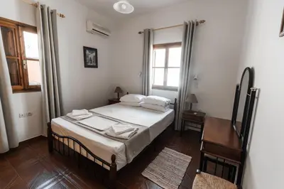 a bedroom with a bed with white sheets and pillows at Perla di Mare - Katoi 1 in Symi