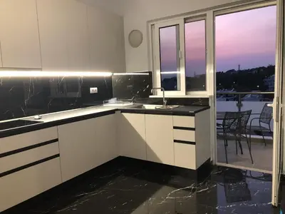a kitchen with white cabinets and a view of a balcony at Kyra Maria 2, view Apartment in Rhodes Town