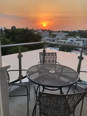 a table and chairs on a balcony with a sunset at Kyra Maria 2, view Apartment in Rhodes Town