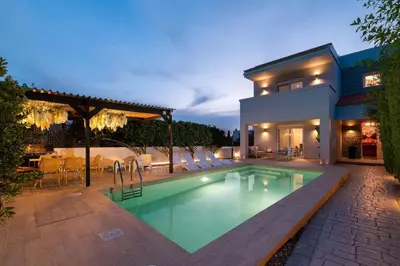 a swimming pool in the backyard of a house at Niovis Villa in Pastida