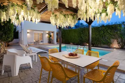 a patio with a table and chairs and a pool at Niovis Villa in Pastida