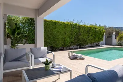 a patio with a pool and chairs and a table at Niovis Villa in Pastida