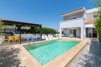 a swimming pool in the backyard of a house at Niovis Villa in Pastida