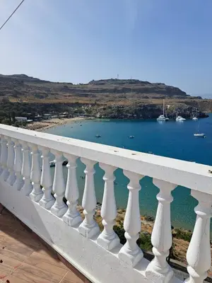 a white balcony with a view of the water at Terrace Studio in Rhodes Town