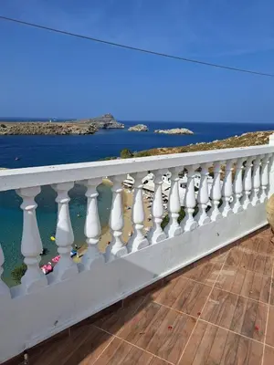 a white railing on a balcony overlooking the ocean at Terrace Studio in Rhodes Town