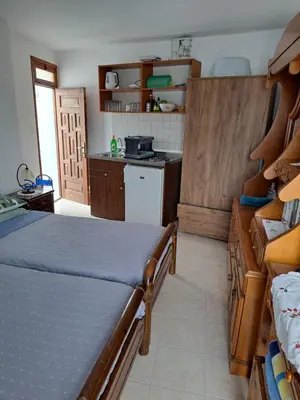 a bedroom with a bed and a kitchen with a stove at Terrace Studio in Rhodes Town