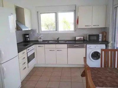 a kitchen with white cabinets and a sink and a dishwasher at Welcome to relaxation in Phanaes