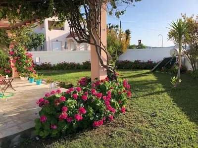 a garden with pink flowers in a yard at Welcome to relaxation in Phanaes