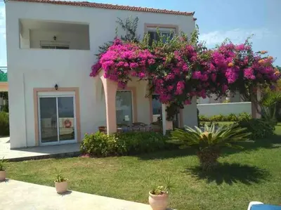 a house with pink flowers in front of it at Welcome to relaxation in Phanaes