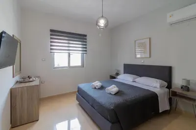 a bedroom with a bed and a flat screen tv at Louka's House in Afantou