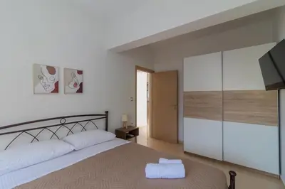 a bedroom with a large bed and a tv at Louka's House in Afantou