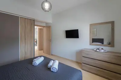 a bedroom with a bed and a dresser and a mirror at Louka's House in Afantou