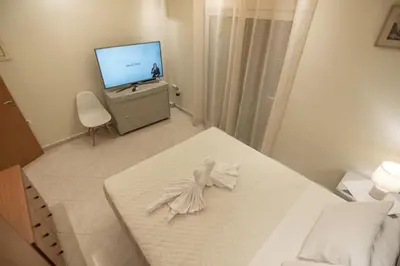 a room with a bed and a tv and a table at Rhodes Views in Rhodes Town