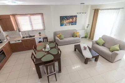 a kitchen and a living room with a table and chairs at Rhodes Views in Rhodes Town