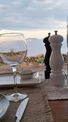 a glass of wine sitting on a table with a view at Nisyros Nest in Nikiá