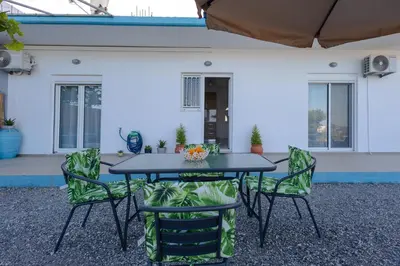a table and four chairs in front of a house at Stefanos House Stegna in Archangelos