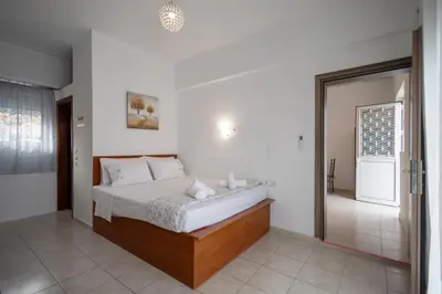 a bedroom with a bed and a door to a bathroom at Stefanos House Stegna in Archangelos