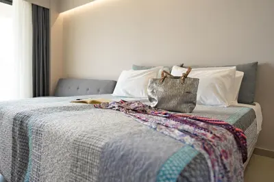 a bed with a purse sitting on top of it at Ampelia Hotel in Gennadi