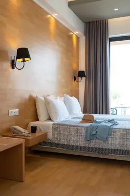 a hotel room with a bed and a window at Ampelia Hotel in Gennadi