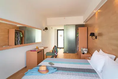a bedroom with a bed with a hat on it at Ampelia Hotel in Gennadi