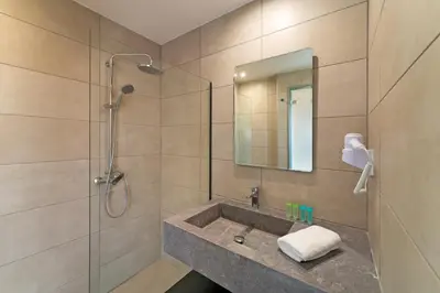a bathroom with a sink and a shower at Ampelia Hotel in Gennadi