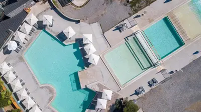 an overhead view of two large swimming pools at Ampelia Hotel in Gennadi