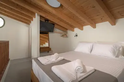 a bedroom with a bed with towels on it at Onar Residences Chalki in Halki