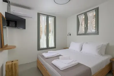 a bedroom with a bed with two towels on it at Onar Residences Chalki in Halki