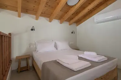 a bedroom with a bed with two towels on it at Onar Residences Chalki in Halki