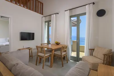 a living room with a table and a couch and a television at Onar Residences Chalki in Halki