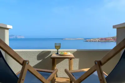 a glass of wine sitting on a table on a balcony at Onar Residences Chalki in Halki