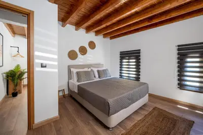 a bedroom with a bed and two windows at D'Amboise House in Rhodes Town