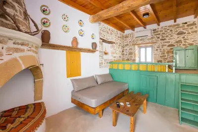 a room with a couch and a table in a kitchen at Amarantos-Traditional Village House-Apollona in Apóllona