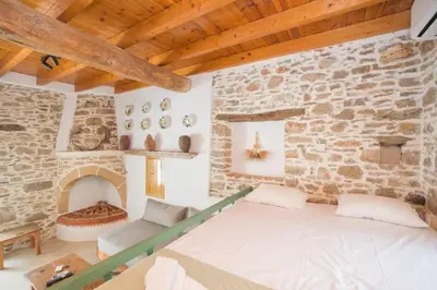a bedroom with a bed and a stone wall at Amarantos-Traditional Village House-Apollona in Apóllona