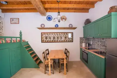 a kitchen with green cabinets and a wooden table at Amarantos-Traditional Village House-Apollona in Apóllona