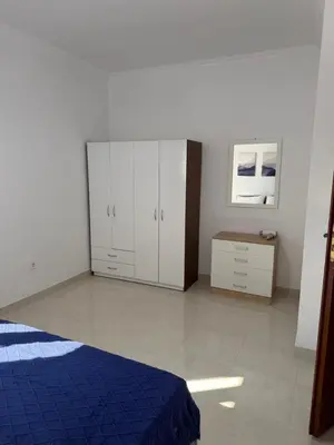a bedroom with a blue bed and white cabinets at Cullura in Asklipiḯon
