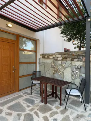 a patio with a wooden table and two chairs at Cullura in Asklipiḯon