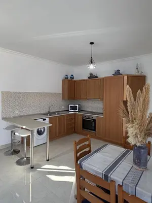 a kitchen with wooden cabinets and a table and chairs at Cullura in Asklipiḯon