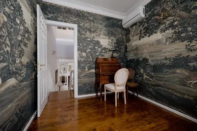 a room with wallpaper with a chair and a piano at Victoria Mansion A Luxurious Neoclassical Experience in Rhodes Town