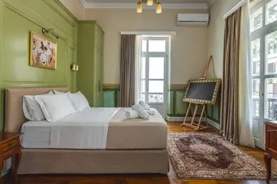 a bedroom with a bed with green walls and a tv at Victoria Mansion A Luxurious Neoclassical Experience in Rhodes Town