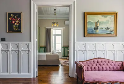 a living room with a pink couch and a painting at Victoria Mansion A Luxurious Neoclassical Experience in Rhodes Town