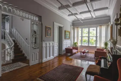 a living room with a staircase and chairs at Victoria Mansion A Luxurious Neoclassical Experience in Rhodes Town